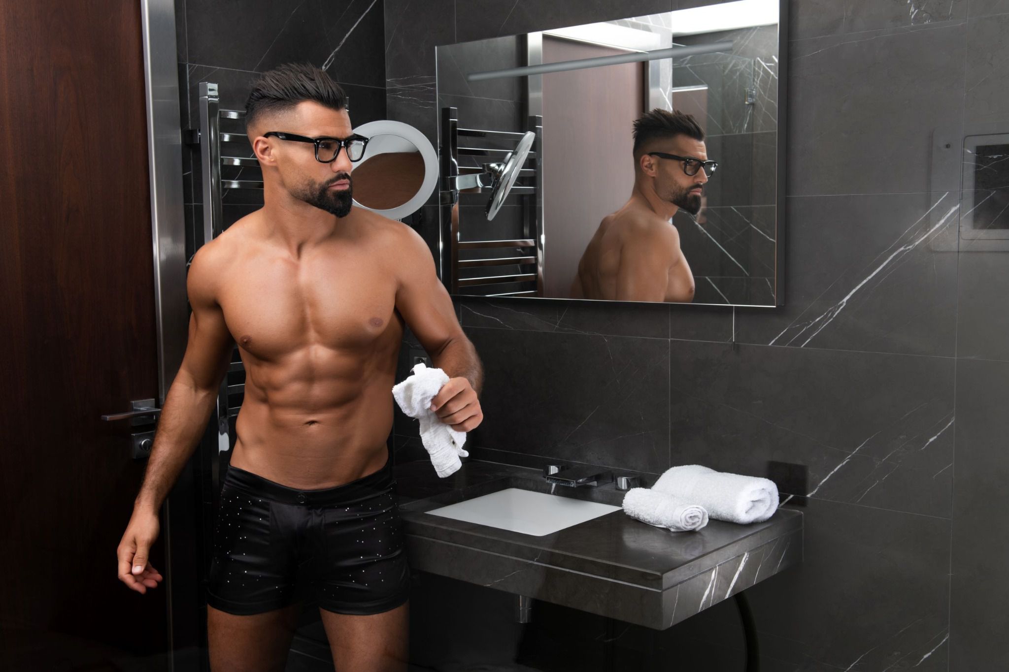 Modèle masculin en boxer DIAMOND se regardant dans le miroir, soulignant le luxe des matériaux avec soie lyonnaise et détails Swarovski.